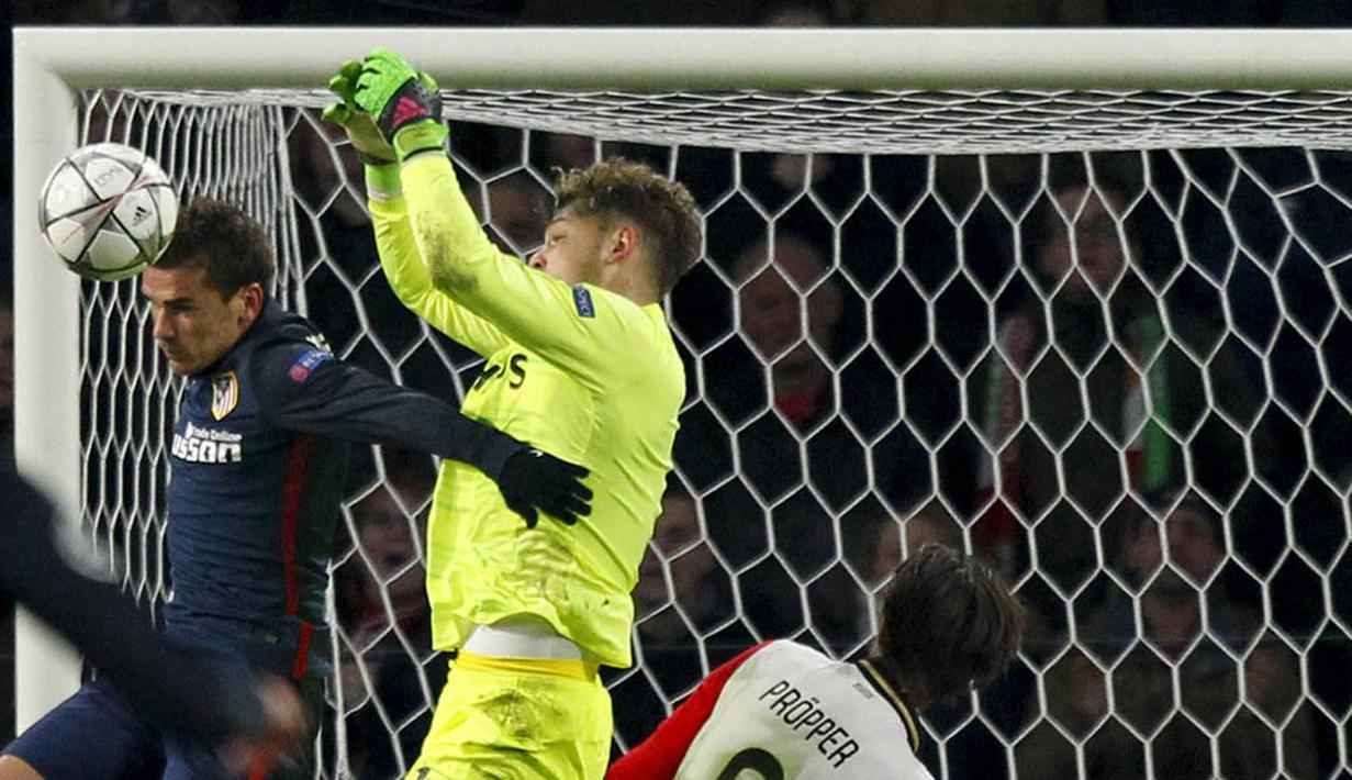 Kiper PSV Eindhoven, Jeroen Zoet, mengamankan bola dari sundulan penyerang Atletico Madrid, Antoine Griezmann. Kedua tim akan bertemu kembali di Madrid pada Rabu (16/3/2016). (Reuters/Michael Kooren)