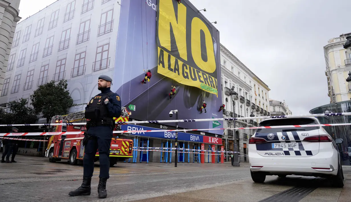 Beberapa negara secara tegas menolak atau mengecam tindakan militer Amerika Serikat dan Israel terhadap Iran, salah satunya Spanyol. Tampak dalam foto, petugas polisi membentuk perimeter saat aktivis Greenpeace membentangkan spanduk besar bertuliskan "Tidak untuk Perang" sebagai bentuk protes terhadap serangan Amerika Serikat (AS) dan Israel terhadap Iran, di Lapangan Puerta del Sol, Madrid, Spanyol, pada Selasa 10 Maret 2026. (Paul Hanna/AFP)