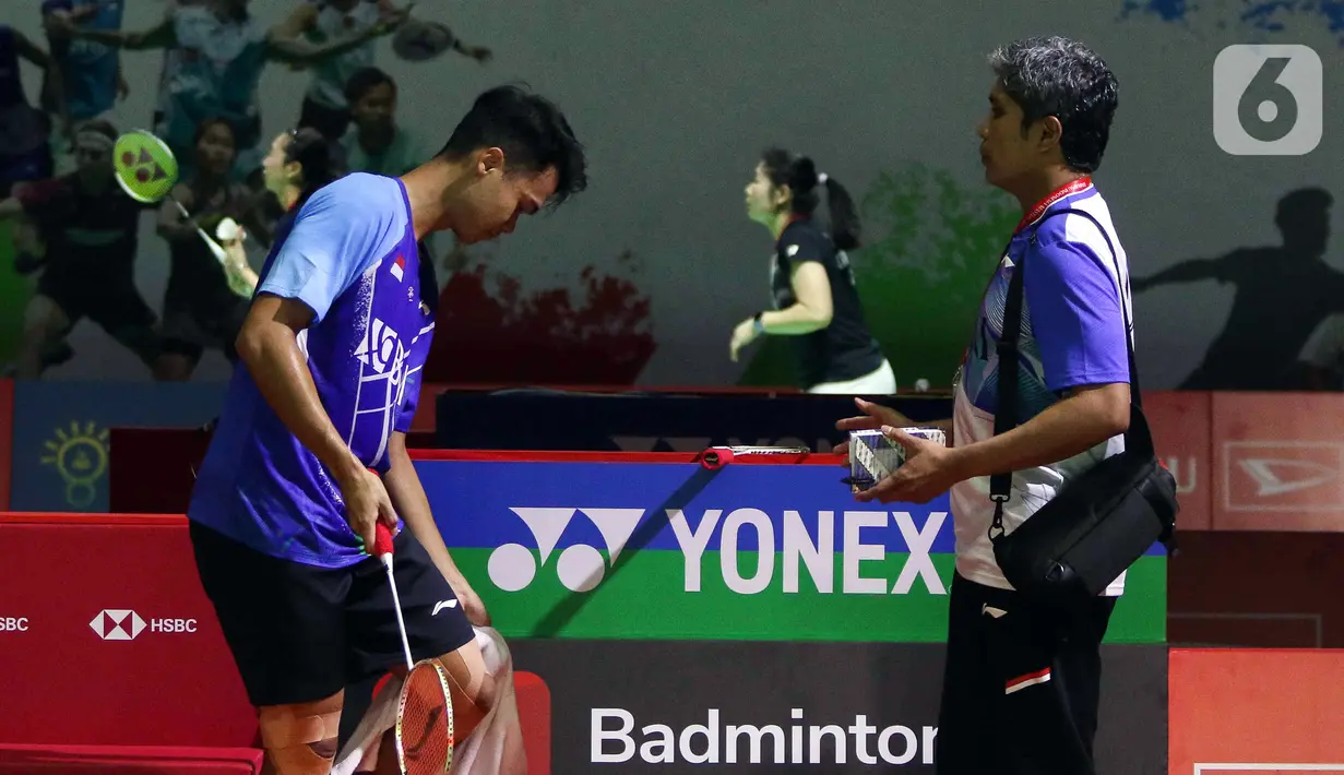 Pebulu tangkis tunggal putra Indonesia Christian Adinata (kiri) beristirahat saat melawan pebulu tangkis tunggal putra Belanda Mark Caljouw pada babak kualifikasi turnamen Daihatsu Indonesia Masters 2023 di Istora Gelora Bung Karno, Jakarta, Selasa (24/1/2023). Christian Adinata menang atas Mark Caljouw dengan skor 20-22, 21-14, dan 21-17. (Liputan6.com/Herman Zakharia)