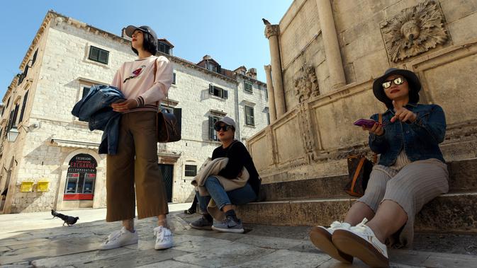 Wisatawan beristirahat di Stradun, jalan utama kota tua Dubrovnik di Kroasia pada 28 Maret 2019. Stradun, atau lebih dikenal dengan Plaka menjadi daya tarik utama para pengunjung yang hilir mudik menikmati suasana kota. (Denis LOVROVIC / AFP)