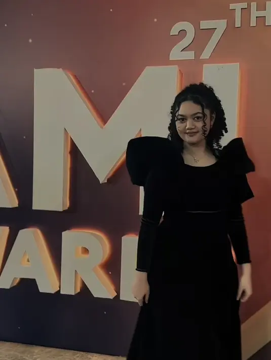 Rambut keriting yang ikonik pun kembali diperlihatkan Amora. Kali ini, rambut hitam keriting dikuncir model mengembang dengan poni belah dia membingkai wajah. [@krisdayanti_official]