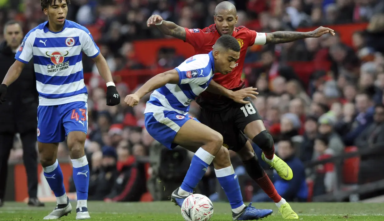 Bek Manchester United, Ashley Young, berebut  bola dengan pemain Reading, Andy Rinomhota, pada laga Piala FA di Stadion Old Trafford, Sabtu (5/1). Manchester United menang 2-0 atas Reading. (AP/Rui Vieira)