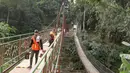 Pekerja menyelesaikan pembangunan jembatan gantung yang diberi julukan Indiana Jones di Srengseng Sawah, Jagakarsa, Jakarta, Jumat (3/8). Pemprov DKI membangun jembatan Indiana Jones karena yang lama sudah tidak layak. (Liputan6.com/Immanuel Antonius)