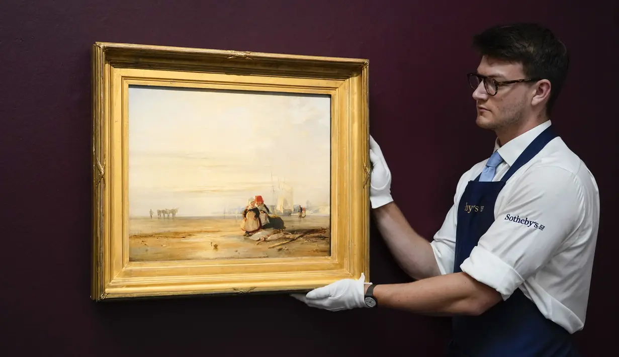 Seorang staf memegang lukisan 'Piccarie Coast with Children - Sunrise' karya Richard Parkes Bonington di Sotheby's, London, Inggris, 22 Juni 2022. Lukisan yang akan dilelang pada 29 Juni 2022 itu diperkirakan memiliki harga 2-3 juta pound. (AP Photo/Alberto Pezzali)