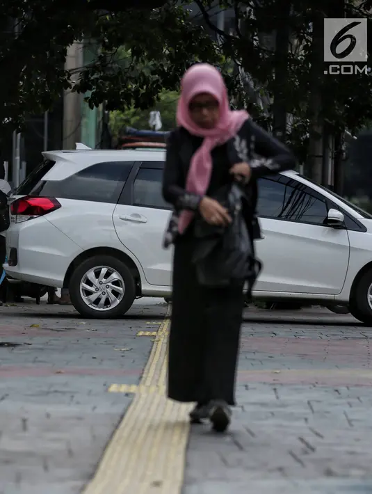 Sebuah mobil menghalangi jalur difabel trotoar di kawasan Sarinah, Jakarta, Rabu (6/1). Kondisi trotoar yang tidak steril ini menyulitkan pejalan kaki, terutama difabel saat melintas. (Liputan6.com/Faizal Fanani)