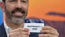 Seperti diketahui, pada pertemuan sebelumnya, Real Madrid harus mengakui keunggulan Benfica dengan skor 2-4. Tampak dalam foto, Mantan pemain sepak bola Prancis dan duta Liga Champions UEFA, Robert Pires, mengangkat slip Real Madrid CF (ESP) selama pengundian babak play-off fase gugur Liga Champions UEFA 2025-2026 di House of European Football, Nyon, Swiss pada 30 Januari 2026. (Harold CUNNINGHAM/AFP)