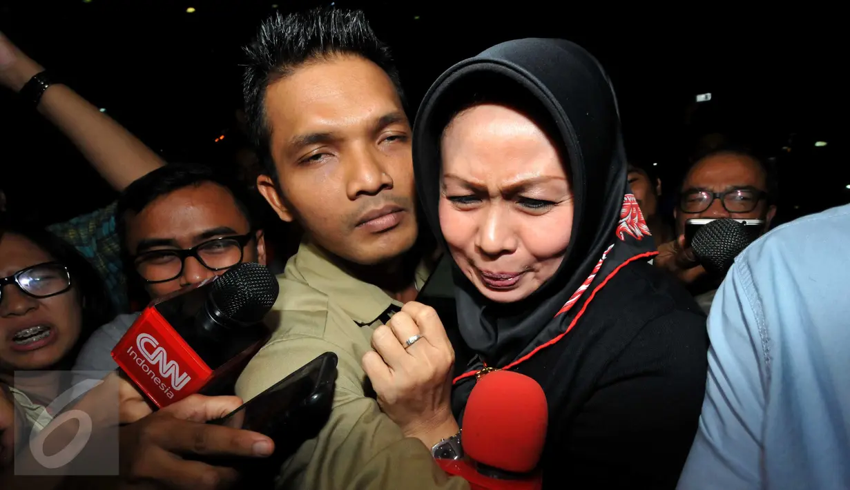 Istri Pelaksana Tugas (Plt) Gubernur Sumatera Utara Tengku Erry Nuradi, Evi Diana, menghindar dari wartawan usai diperiksa KPK, Jakarta, Kamis (5/11/15). Evi yang diperiksa sebagai saksi untuk Gatot Pujo Nugroho. (Liputan6.com/Helmi Afandi) 