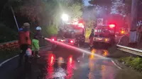 Petugas BPBD dibantu unit pemadam kebakaran membersihkan Jalan Tulungrejo, Kota Batu, yang terendam air bercampur material lumpur pada Jumat, 26 Januari 2024 sore&nbsp;