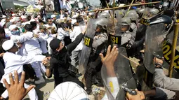 Petugas saat terlibat bentrok dengan ratusan ormas Islam di depan Gereja Katolik Santa Clara, Bekasi, Jawa Barat, (24/3). Aksi bentrokan tersebut membuat sejumlah aparat kepolisian dan pemuda Ormas Islam terluka. (AP Photo/Achmad Ibrahim)