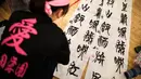 Peserta menulis kaligrafi Jepang selama kontes kaligrafi untuk merayakan tahun baru di Tokyo, Sabtu (5/1). Sudah menjadi tradisi di Jepang jika semangat tahun baru digoreskan di atas kanvas dengan tulisan kaligrafi. (Behrouz MEHRI / AFP)