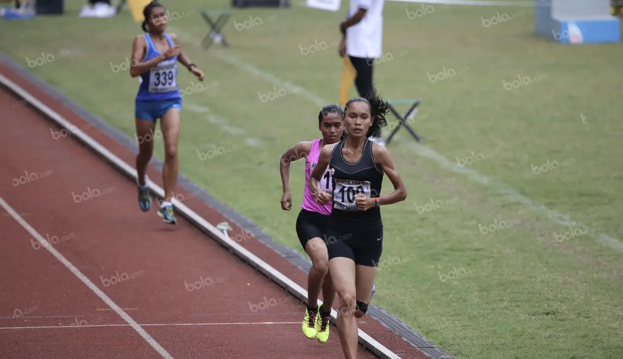 Atlet DKI Jakarta, Rini Budiarti (kanan), meraih emas lari 5000m putri PON XIX Jawa Barat 2016 setelah mengalahkan rekannya, Triyaningsih, dalam final di Stadion Pakansari, Bogor, Kamis (22/9/2016). (Bola.com/Arief Bagus)