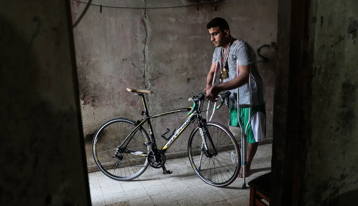 Atlet sepeda asal Palestina, Alaa Al-Daly berdiri di samping sepeda miliknya di Rafah, Jalur Gaza, 19 April 2018. Setelah kehilangan kaki, kini Alaa Al-Daly bertekad melanjutkan mimpinya di ajang Paralympiade atau Asian Para Games. (AFP/SAID KHATIB)