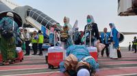 Jemaah haji melakukan sujud syukur usai tiba di bandara Juanda. (Dian Kurniawan/Liputan6.com)