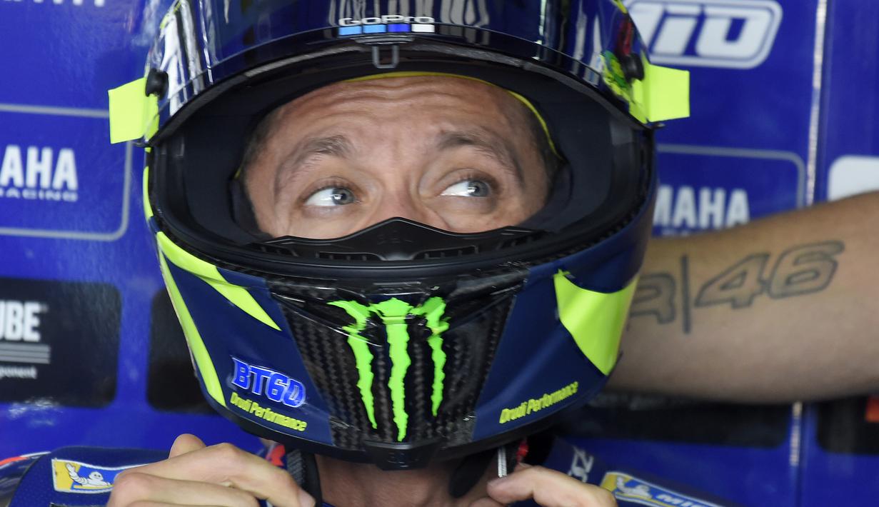 Pebalap Movistar Yamaha, Valentino Rossi, berdiskusi dengan timnya saat sesi latihan MotoGP Aragon di Sirkuit Aragon, Spanyol, Sabtu (21/9/2018). Pada sesi latihan ini, pria Italia itu hanya menduduki posisi kesembilan. (AFP/Jose Jordan)