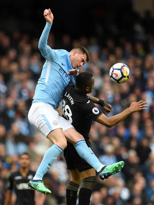 Duel pemain Manchester City, Aymeric Laporte (kiri) dengan pemain Swansea City, Jordan Ayew pada lanjutan Premier League di Etihad Stadium, Manchester, (22/4/2018). Manchester City menang 5-1. (AFP/Paul Ellis)