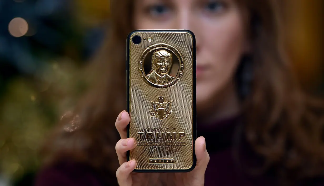 Seorang karyawan dari Caviar Phones memperlihatkan iPhone 7 edisi khusus dengan potret muka Donald Trump di Moskow, Rusia, 14 November 2016. iPhone mewah ini juga ditaburi dengan kristal Svarowsky dan titanium di beberapa sisinya. (Vasily Maximov/AFP)