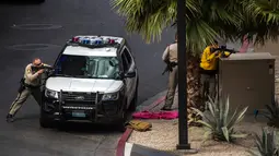 Tim SWAT mengepung pelaku penembakan di dekat hotel sekaligus kasino terkemuka Cosmopolitan, Las Vegas, Sabtu (25/3). Pria bertopeng babi tiba-tiba mengeluarkan tembakan dan membuat para turis melarikan diri dari hotel. (L.E. Baskow/Las Vegas Sun via AP)