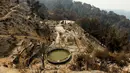 Sebuah rumah hancur setelah hangus terbakar akibat kebakaran hutan di kawasan Palo Colorado, Big Sur, California, Amerika Serikat, AS, (1/7). Seluas 8.000 hektare hutan terbakar akibat musibah tersebut. (REUTERS/Michael Fiala)