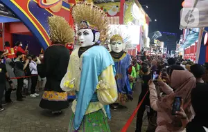 Pengunjung melihat parade karnaval pada Jakarta Fair ke-53 atau Pekan Raya Jakarta (PRJ) di JiExpo Kemayoran, Jakarta Pusat, Selasa (21/6/2022) malam. Adapun kegiatan ini dilaksanakan dalam rangka menyambut Hari Ulang Tahun (HUT) ke-495 Jakarta yang jatuh pada Rabu, 22 Juni 2022. (Liputan6.com/Herman Zakharia)