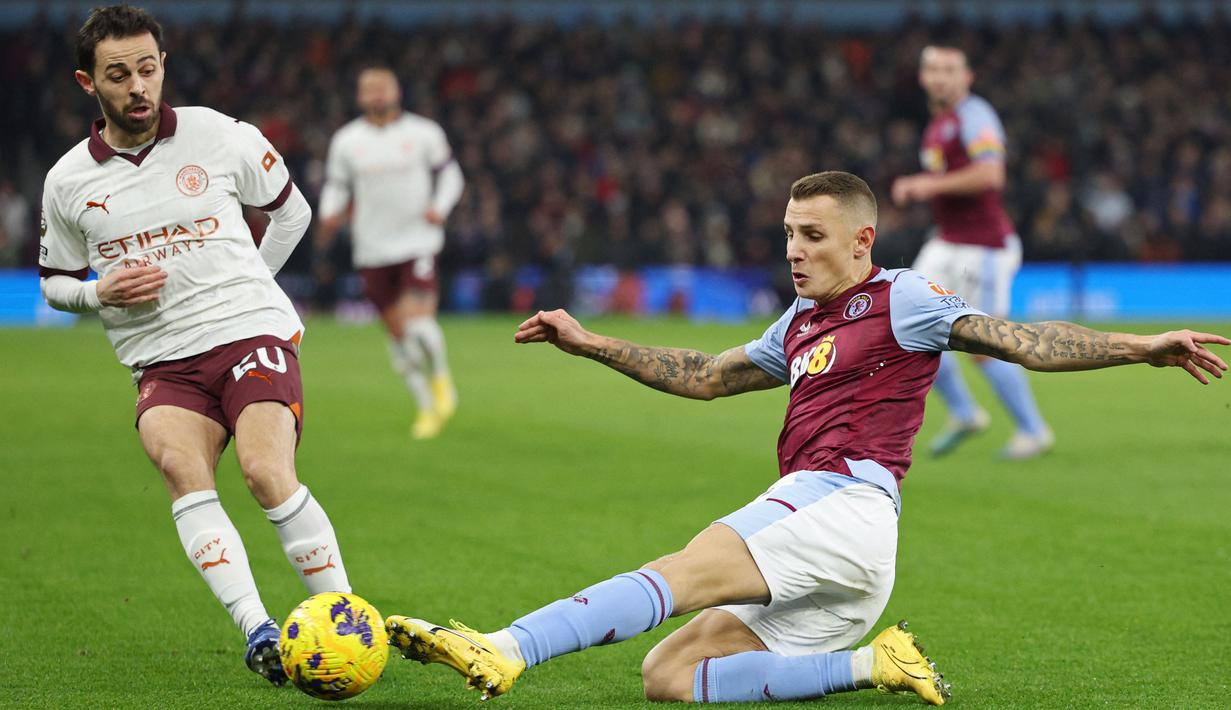 Pemain Aston Villa, Lucas Digne, berebut bola dengan pemain Manchester City, Bernardo Silva, pada laga lanjutan pekan ke-15 Premier League di Stadion Villa Park, Kamis (07/12/2023). City takluk 0-1 dari tuan rumah. (AFP/Adrian Dennis)