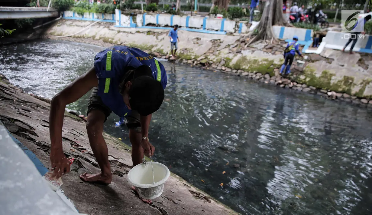 Petugas Suku Dinas Tata Air melakukan pengecatan bantaran Kali Gresik, Menteng, Jakarta, Minggu (29/10). Kali Gresik juga disebut sistem drainase Menteng adalah kali percontohan di Ibu Kota untuk tidak membuang sampah di kali. (Liputan6.com/Faizal Fanani)