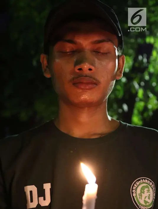 Peserta memanjatkan doa saat menyalakan lilin dalam aksi solidaritas terkait tragedi teror bom di Surabaya dan Sidoarjo di Taman Suropati, Jakarta, Senin (14/5). (Liputan6.com/Immanuel Antonius)