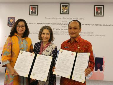 Chief Marketing Officer DOKU, Himelda Renuat, Chief Operating Officer DOKU, Nabilah Alsagoff dan Dirjen Dukcapil Zudan Arif Fakrulloh menunjukkan perjanjian kerja sama pemanfaatan data kependudukan di Jakarta, Jumat (11/1). (Liputan6.com/Fery Pradolo)