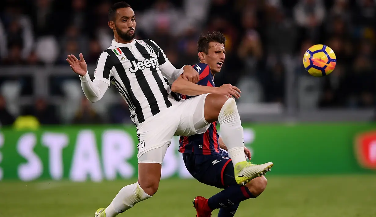 Pemain Juventus, Medhi Amine Benatia (kiri) berebut bola dengan pemain Crotone, Alexander Tonev pada lanjutan Premier League di Allianz Stadium, Turin, Italy, (26/11/2017). Juventus menang 3-1. (AFP/Marco Bertorello)