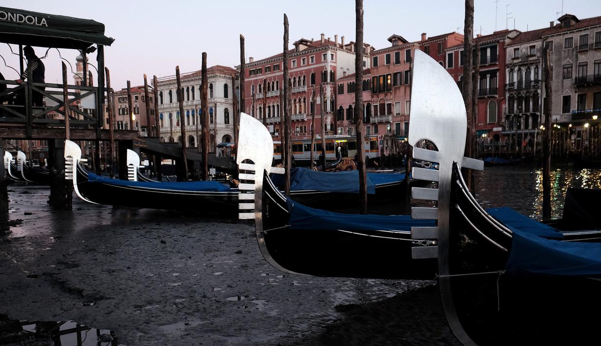 Perahu Gondola bersandar di laguna Venesia, Italia (29/12). Surutnya kanal ini mengakibatkan Gondola sulit berjalan dan banyak bersandar di pinggir Grand Canal di laguna Venesia, Italia. (REUTERS/Manuel Silvestri)