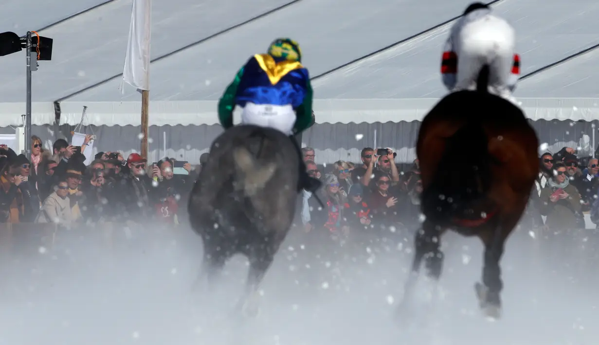 Penonton menyaksikan peserta memacu kudanya saat lomba Flat Course selama pacuan kuda White Turf di danau beku, Saint Moritz, Swiss, 17 Februari 2019. Pacuan kuda ini diadakan pada Februari ketika danau St. Moritz masih beku. (STEFAN WERMUTH / AFP)