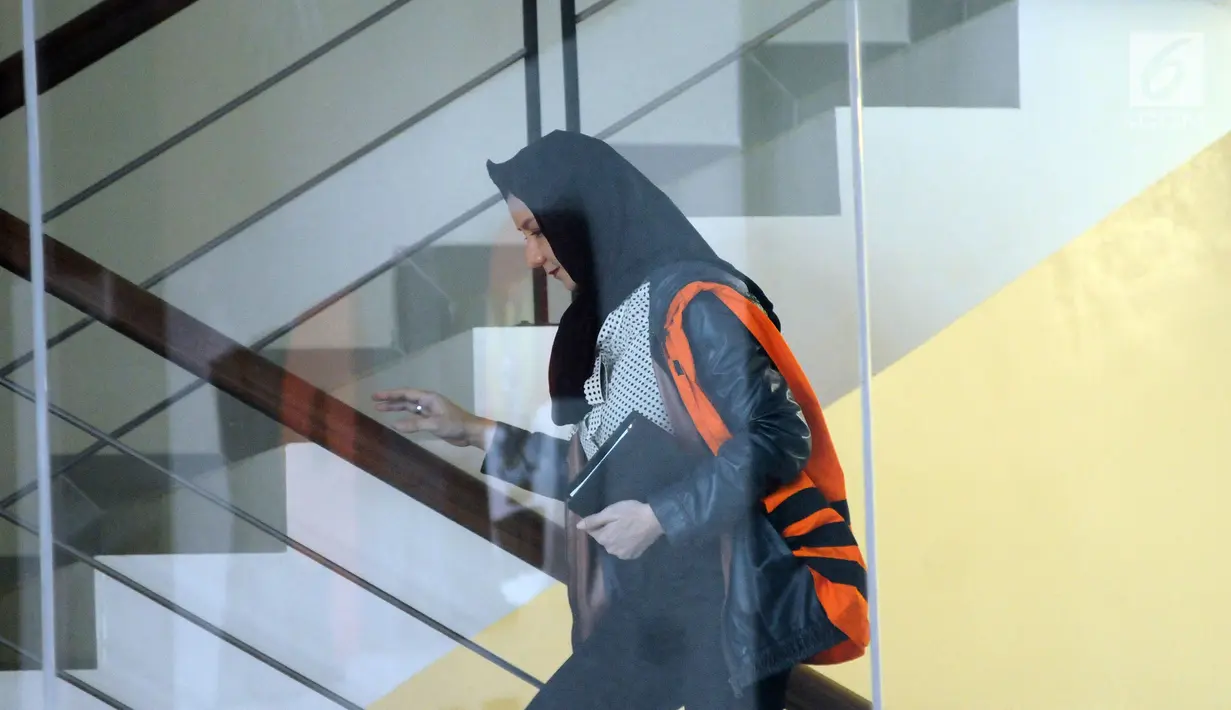 Bupati (nonaktif) Kutai Kartanegara, Rita Widyasari menaiki tangga gedung KPK untuk menjalani pemeriksaan lanjutan, Jakarta, Rabu (25/10). Rita menjadi tersangka di dua kasus berbeda atas dugaan suap dan gratifikasi. (Liputan6.com/Helmi Fithriansyah)