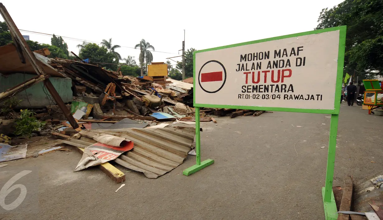 Sebuah plang penutup jalan terpampang di Jalan Rawajati Barat, Jakarta, Jumat (2/9). Pasca penggusuran pemukiman di bantaran rel kereta kawasan Rawajati, sejumlah warga masih memilih bertahan tinggal di lokasi. (Liputan6.com/Helmi Fithriansyah)