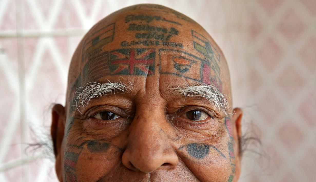 Guinness Rishi saat menunjukan tato di bagian kepalanya di apartemennya di New Delhi, India (20/5). Guinness Rishi merupakan pemegang rekor dunia yang paling banyak menato bendera negara dari seluruh dunia. (REUTERS/Cathal McNaughton)