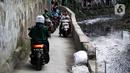 Sejumlah pengendara sepeda motor melintasi jalur alternatif di belakang Kompleks Patra Jasa, Jakarta Selatan, Rabu (1/3/2023). Jalur alternatif seperti gang, jalan kecil, maupun jalan tembusan menjadi pilihan bagi pengendara sepeda motor untuk menghindari kemacetan di jalan-jalan protokol Ibu Kota. (Liputan6.com/Johan Tallo)