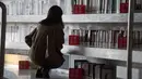 Seorang wanita mencari buku saat mengunjungi Perpustakaan Binhai Tianjin di China (14/11). Bangunan ini memiliki lima lantai yang terdiri dari ruang baca lapang, lounge untuk bersantai, kantor, ruang rapat, dan ruang audio-komputer. (AFP/Fred Dufour)