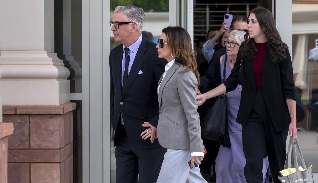 Baldwin lantas berjalan keluar bergandengan tangan melalui kerumunan pers menuju kendaraan hitam tanpa menjawab pertanyaan atau memberikan komentar. (Eddie Moore/The Albuquerque Journal via AP)