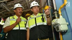 Menteri ESDM Ignasius Jonan dan Dirut PT Perusahaan Gas Negara (PGN) Jobi Triananda Hasjim saat melihat jaringan gas bumi rumah tangga di Kecamatan Prajurit Kulon, Mojokerto, Jawa Timur (13/8). (Liputan6.com/Pool)