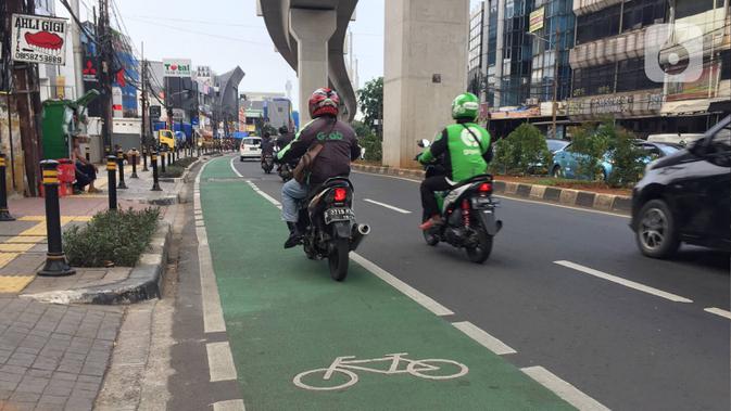 Pengendara sepeda motor melintasi jalur khusus sepeda di Jalan Fatmawati Raya, Jakarta, Rabu (22/1/2020). Kurangnya penerapan sanksi menyebabkan jalur khusus bagi pesepeda tersebut tidak steril dari kendaraan bermotor. (Liputan6.com/Immanuel Antonius)