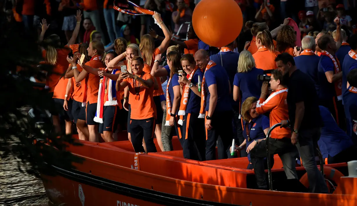 Tim sepak bola wanita Belanda menyapa para pendukung dari atas perahu saat merayakan kemenangannya di Utrecht, Belanda (7/9). Timnas dan tuan rumah Belanda berhasil mengalahkan Denmark 4-2. (AFP Photo/John Thys)