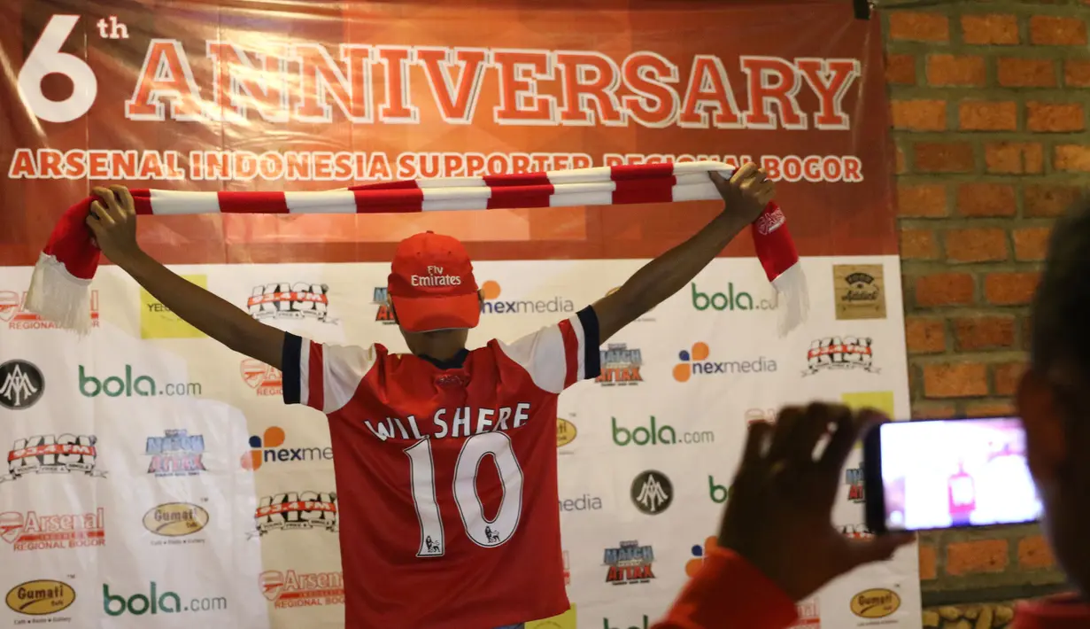 Seorang Anggota Arsenal Indonesia Supporters (AIS) berfoto sebelum acara nonton bareng Newcastle United vs Arsenal dimulai di Gumati Cafe, Bogor. Sabtu (29/8/2015). (Bola.com/Arief Bagus)