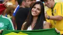 Seorang fans cantik asal Brasil tersenyum manis saat menonton semifinal sepak bola antara Brasil melawan Honduras pada ajang Olimpiade Rio 2016 di Stadion Maracana, Rio de Janeiro, Brasil, (17/8/2016). (AFP/Martin Bernetti)