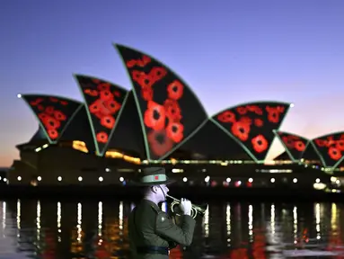 Bunga poppy diproyeksikan ke layar Opera House saat angkatan bersenjata Australia memainkan 'The Last Post' Remembrance Day Dawn Service di Sydney, Jumat (11/11/2022). Remembrance Day 2022 menandai 104 tahun sejak Gencatan Senjata yang mengakhiri Perang Dunia Pertama pada 11 November 1918. (Saeed KHAN / AFP)