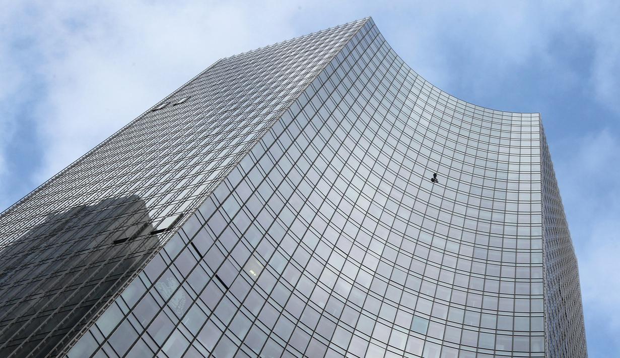 Pendaki kota Prancis, Alain Robert saat berusaha memanjat gedung XYZ di Frankfurt am Main, Sabtu (28/9/2019). Alain yang dikenal sebagai "The French Spiderman" kembali memanjat gedung tinggi di kota Jerman tersebut. (AFP Photo/Daniel Roland)