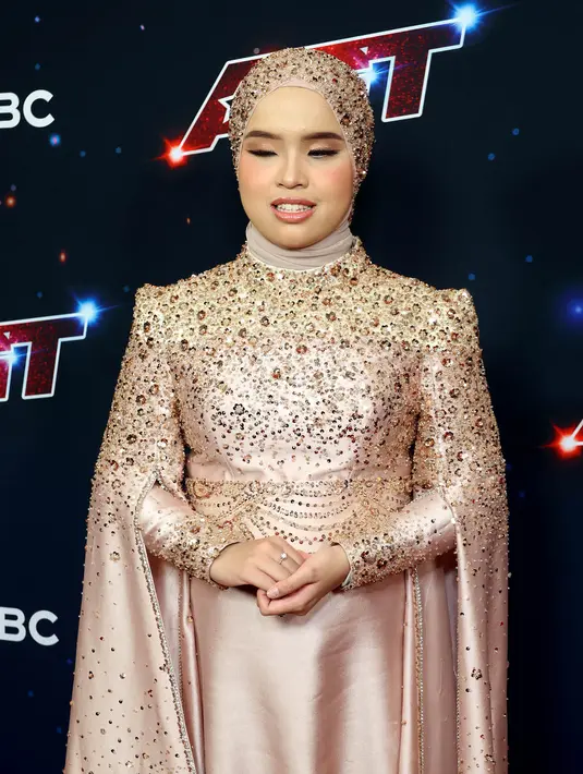 Putri Ariani selalu tampil mengenakan gaun yang dilengkapi aksen ekor panjang berpayet berpadu hijab warna senada. (Monica Schipper/Getty Images North America/Getty Images via AFP)