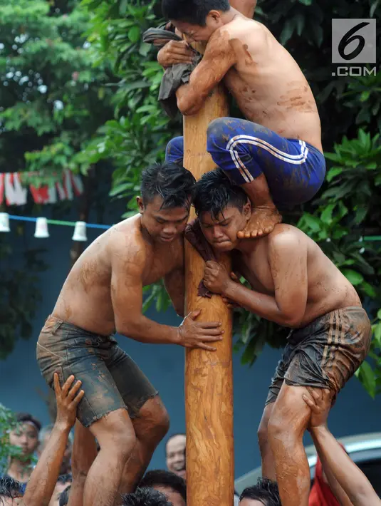 Para peserta berupaya mangambil hadiah, pada lomba panjat pinang di Perumahan Griya Pamulang 2, Tangerang Selatan, Jumat (17/8). Lomba yang diselengarakan oleh Bina Remaja ini dalam rangka memeriahkan HUT Ke-73 RI. (Merdeka.com/Dwi narwoko)