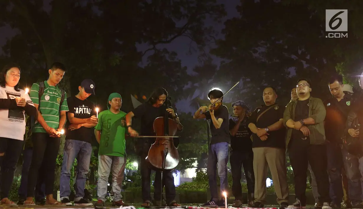 Gabungan suporter klub sepak bola bernyanyi dalam aksi solidaritas terkait tragedi teror bom di Surabaya dan Sidoarjo di Taman Suropati, Jakarta, Senin (14/5). Para suporter mengutuk teror yang terjadi di Indonesia. (Liputan6.com/Immanuel Antonius)