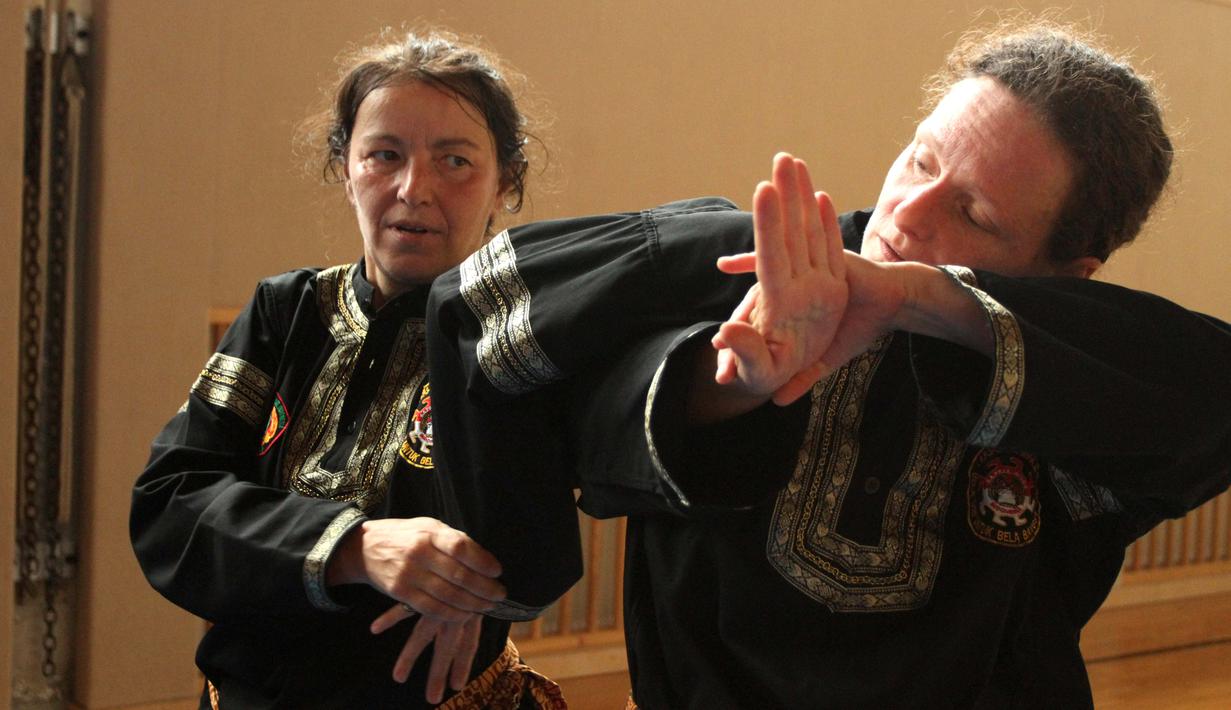 Dua murid wanita sekolah pencak silat Anak Harimau tengah memperagakan teknik serangan. (Bola.com/Reza Khomaini)