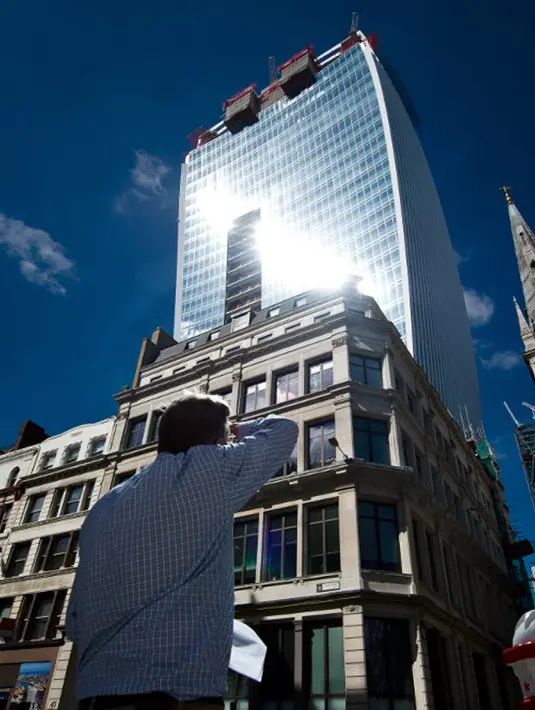 Seorang pria melihat Walkie Talkie, gedung pencakar langit di Kota London, 3 Agustus 2013. Gedung bertingkat 37 ini memenangkan Piala Carbuncle yang diberikan setiap tahun kepada gedung yang dipandang sebagai terburuk di Inggris. (AFP Photo/Leon Neal)