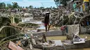 Seorang warga berjalan di antara rumah-rumah yang rusak akibat terjangan Topan Kalmaegi di Talisay, Provinsi Cebu, Filipina pada Rabu 5 November 2025. Cebu, rumah bagi lebih dari 2,4 juta penduduk, kini berada dalam status bencana. (Jam STA ROSA/AFP)