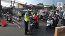 Petugas polisi memeriksa kelengkapan Surat Tanda Registrasi Pekerja  (STRP) bagi pengendara bermotor pada pos  perpanjangan Pemberlakuan Pembatasan Kegiatan Masyarakat (PPKM) Jalan Raya Ir.H.Djuanda, depan Sandratex, Tangerang Selatan, Kamis (15/07/2021). (merdeka.com/Arie Basuki)